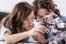 Dos niñas jugando con un robot.