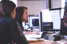 Dos mujeres trabajando delante de una pantalla.