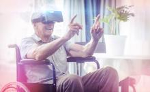 Una persona mayor en silla de ruedas utiliza unas gafas de realidad virtual.