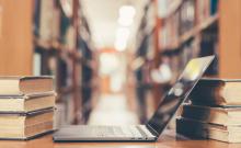 Un ordenador colocado entre libros viejos en una biblioteca.