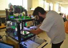 Home manipulando impresora 3D.